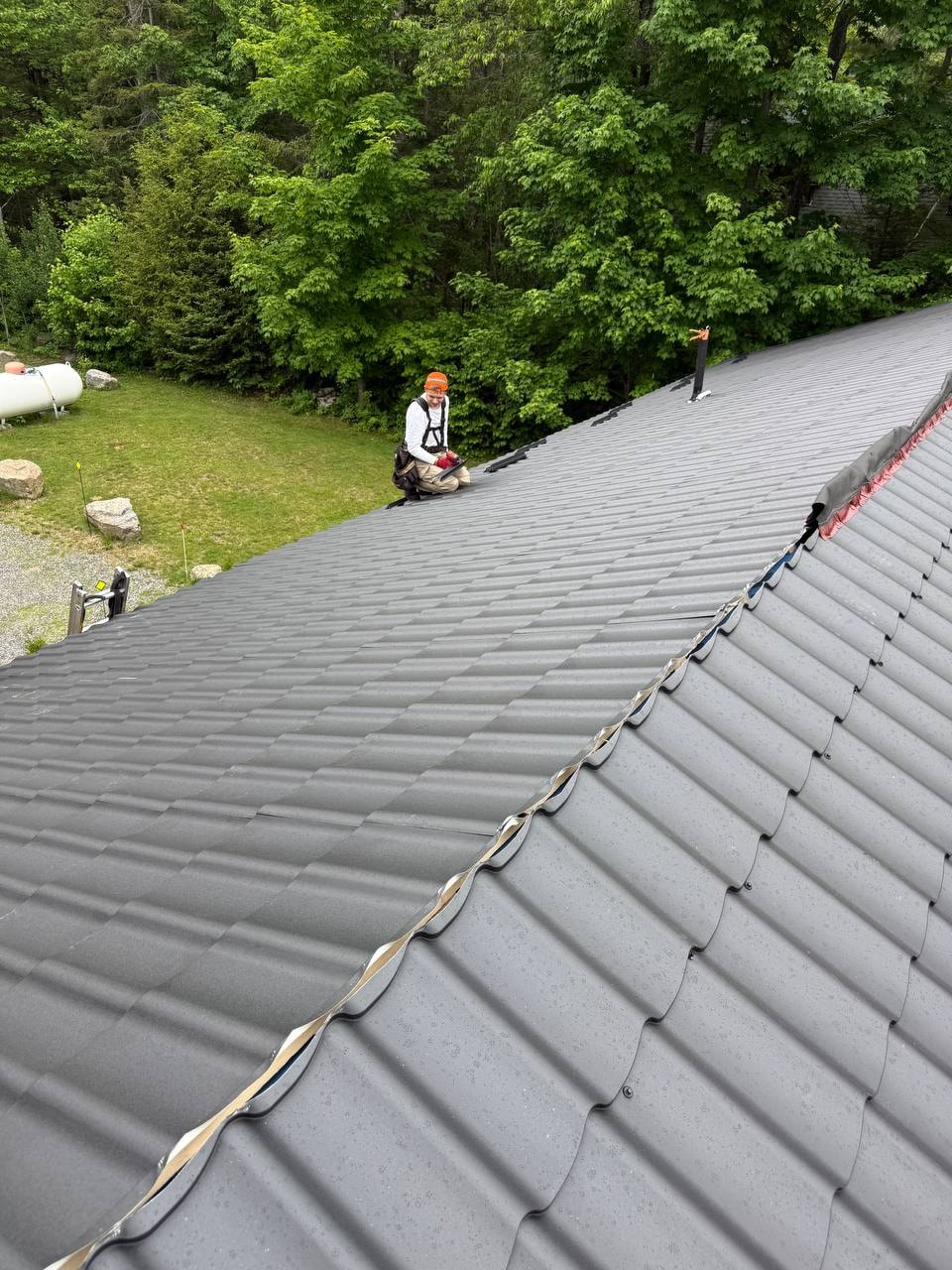 Roofer installing metal tile panels