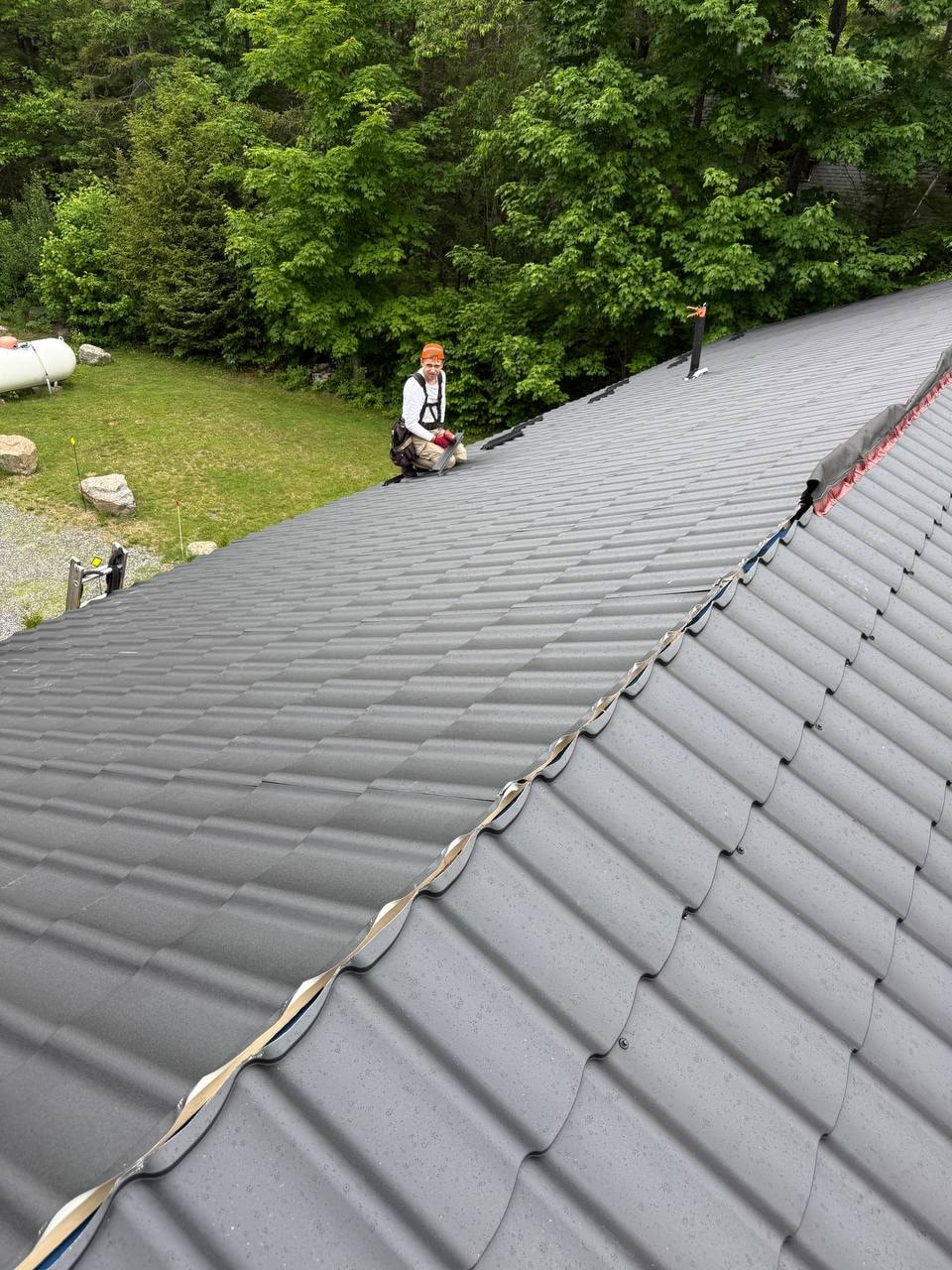 Roofer working on metal tile roof