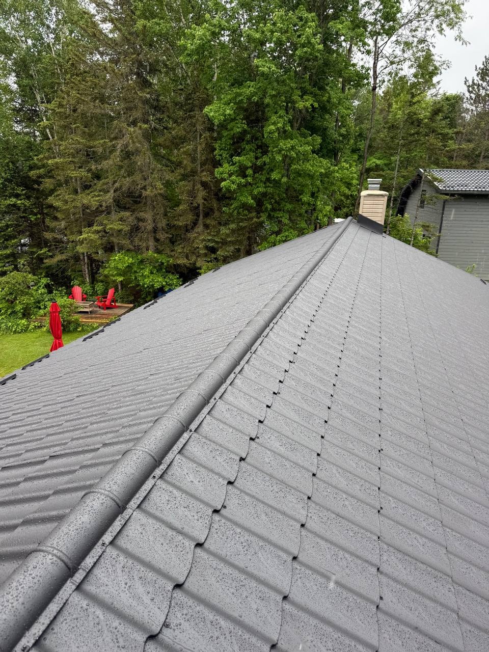 Finished metal roof with red Adirondack chairs below